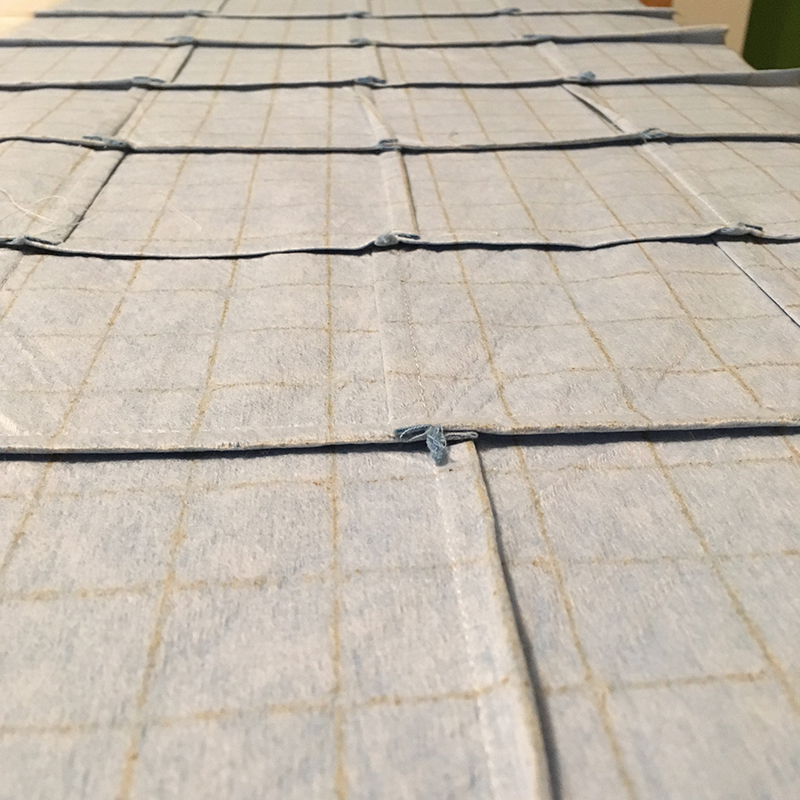 Stitching is complete on this section of fabric. The backside of the top layer shows the seams pressed in alternating directions. 