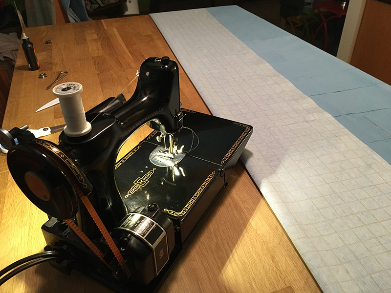 The fabric is folded and ready to be seamed. A Singer Featherweight sewing machine stands ready to go to work.