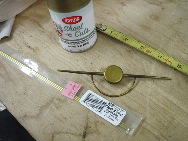 The broken dial pointer, a small can of Krylon Short Cuts gold paint, and some 1/16&&Prime; round brass stock.